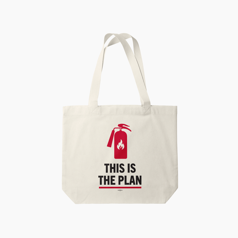 Cream canvas tote bag with a red fire extinguisher graphic and “This Is The Plan”